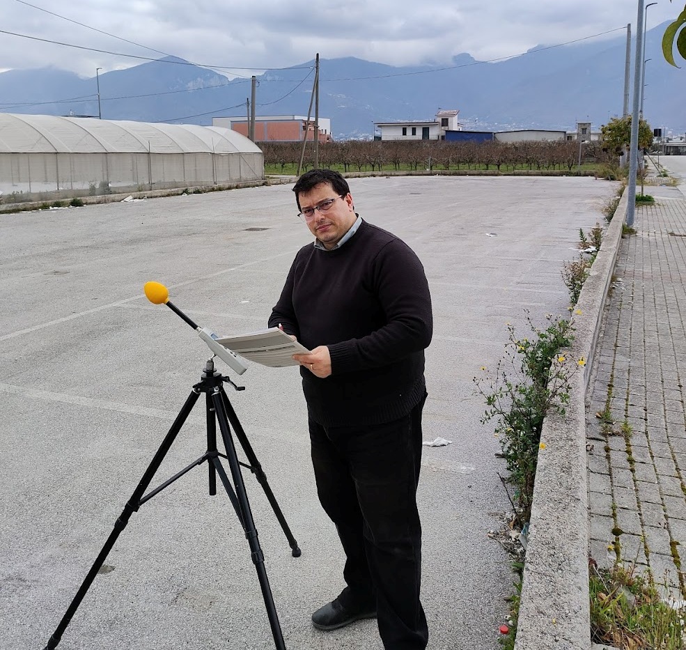 Tecnico A2C durante una misurazione di campi elettromagnetici con strumento su treppiede all'aperto